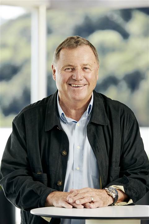 Hubert Palfinger Senior sat at a desk, casual, friendly. Photo: Palfinger AG